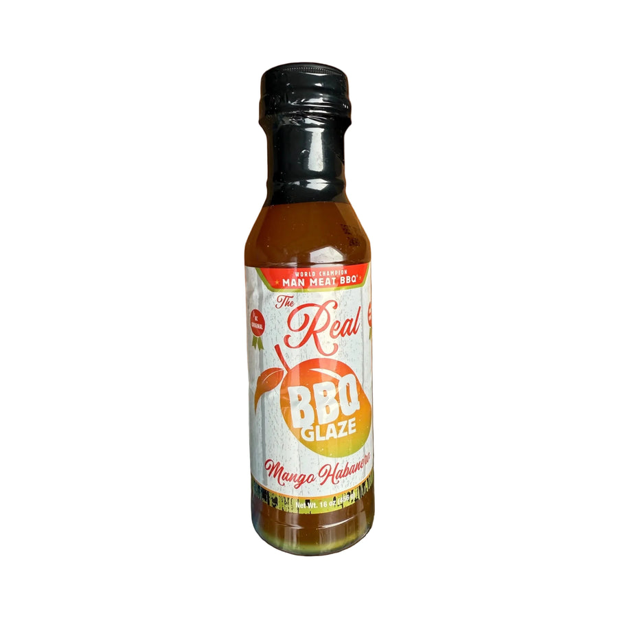 Bottle of 'The Real BBQ Glaze' on a wooden surface with an orange background